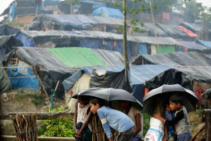 Rohingya refugees stand under the rain waiting for relief near a camp at Tengkhal, Ukhiya, Coxsbazar, Bangladesh, 03 October 2017. Photo: Abir Abdullah/EPA-EFE
