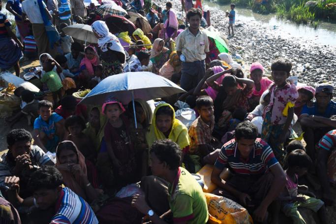Rohingya refugees who had been stranded in the 'no-man's land' between Myanmar and Bangladesh wait with their belongings in Palongkhali after crossing into Bangladesh's Ukhia district on November 3, 2017. Photo: AFP
