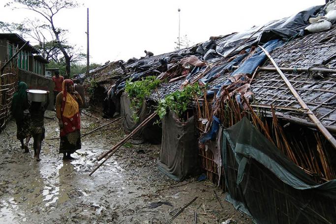 Rohingya refugees walk next to huts in a makeshift camp in Bangladesh's Cox's Bazar district on May 30, 2017. Photo: AFP
