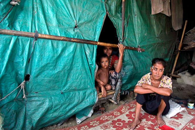 Bangali so called Rohingya women and a child sit at their makeshift house at the ThetKelPyin Muslim refugee camp in Sittwe, Rakhine State, western Myanmar, 06 August 2015. Photo: Nyunt Win/EPA

