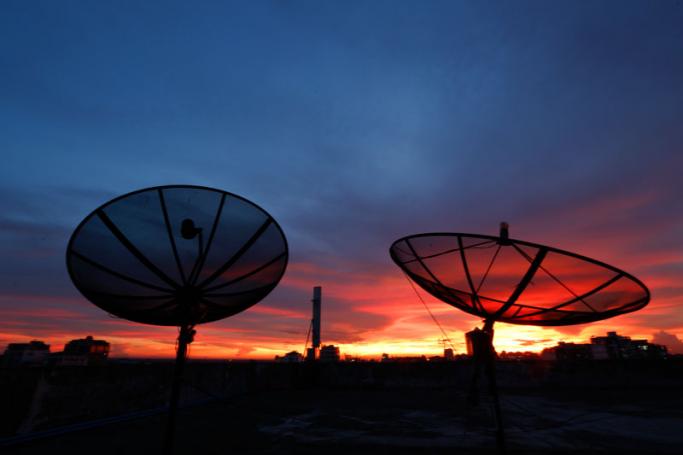 A view of satellite TV dishes, mounted on a building, at sunset in Yangon. Photo: Lynn Bo Bo/EPA
