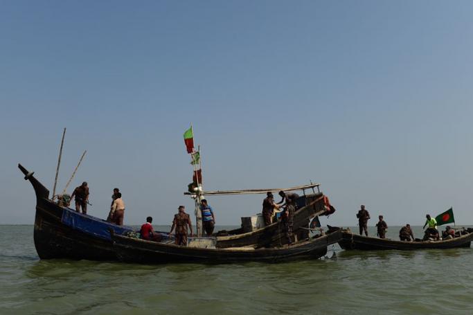 (File) Bangladesh Border Guard (BGB) personnel searching a fishing boat during their patrol along the Naf River in Teknaf, along the border between Myanmar and Bangladesh on April 6, 2018. Photo: AFP