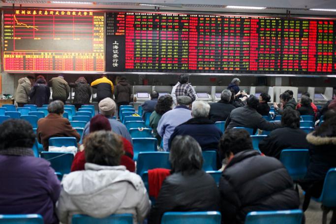 Investors watch the stock trading board at a securities exchange house in Shanghai, China. Photo: EPA
