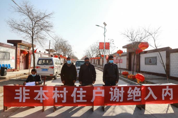 (File) This photo taken on January 27, 2020 shows staff members wearing facemasks standing guard at a check point at the entrance of a village, to stop the entry of outsiders, in Zhangye, in China's northwestern Gansu province. Photo: AFP