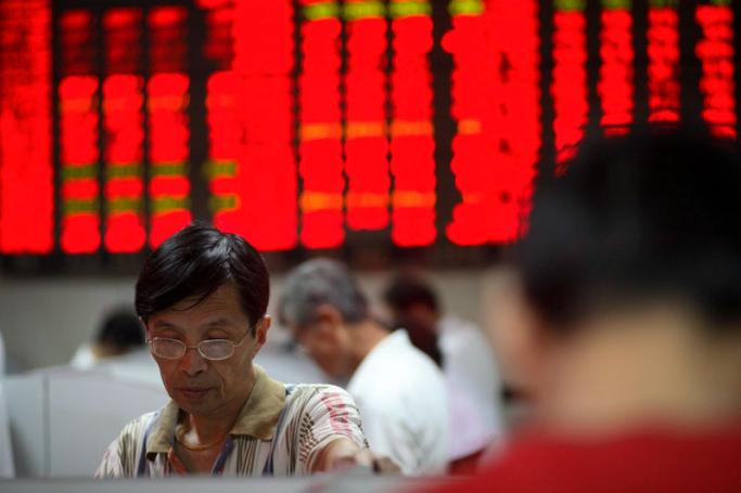 Investors watch the stock trading board at a securities exchange house in Shanghai, China. Photo: Qilai Shen/EPA
