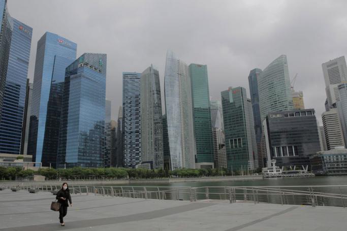 A woman walks along the Marina Bay next to the financial district in Singapore, 14 July 2020. Photo: EPA