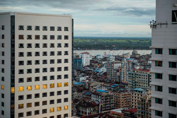 In this picture taken on July 29, 2016, two hotel high rise towers partially obscures the skyline of old Yangon with a view of Yangon river in the background. Photo: Romeo Gacad/AFP
