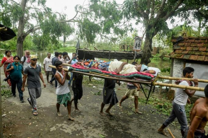 Residents carry Tapas Pramanik (C), 41, after his leg got broken by a tree fall the night before, in search of an ambulance or vehicle to take him to the hospital, following the landfall of cyclone Amphan in Khejuri area of Midnapore, West Bengal, on May 21, 2020. Photo: AFP