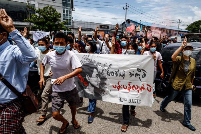 Protesters make the three-finger salute as they take part in a demonstration against the military coup and mark the birthday of Myanmar's detained civilian leader Aung San Suu Kyi in Yangon on June 19, 2021. Photo: AFP