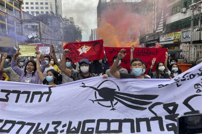 Demonstrators holding posters, flaming torches and flares, march during an anti-military coup protest at downtown area in Yangon, Myanmar, 26 June 2021.  Photo: EPA