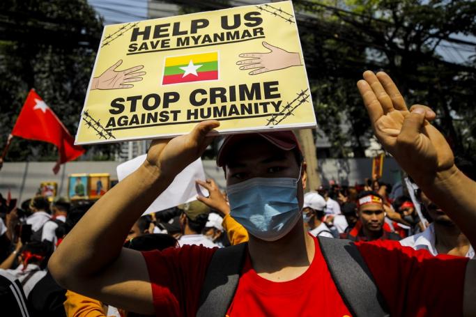 Protesters flash the three finger salute while holding placards during a demonstration to mark the second anniversary of Myanmar's 2021 military coup, outside the Embassy of Myanmar, in Bangkok, Thailand, 01 February 2023. Photo: EPA