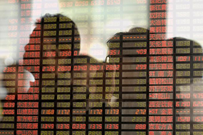 A multiple exposure picture shows Chinese investors monitor the index price at a stock exchange market in Shanghai, China. Photo: EPA
