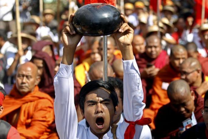 A student shouts slogans as he holds up a Buddhist alm bowl during a march on the road at Letpadan, Bago division, Myanmar, March 3, 2015. Photo: Nyein Chan Naing/EPA
