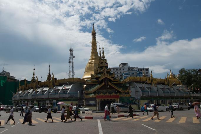 People walking in front of the Sule Pagoda in downtown area of Yangon. Photo: Ye Aung Thu/AFP
