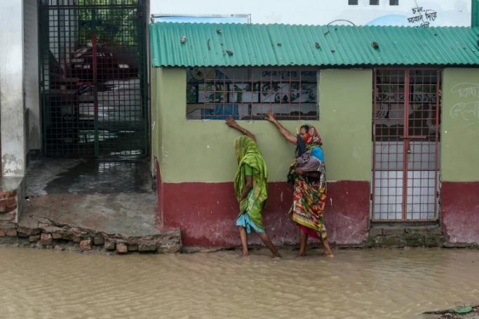 Residents make their way along a flooded street to a shelter ahead of the expected landfall of Cyclone Amphan, in Dacope, Bangladesh, on May 20, 2020 (AFP Photo / Munir uz Zaman)