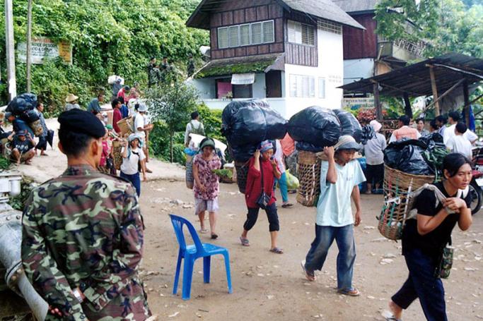 (File) Thai soldiers in Mae Sai, Thailand, monitor 15 June 2002 the flow of people and traders moving between border towns Tachilek (Myanmar) and Mae Sai to prevent the frequent illegal crossing of traders to the well-known black markets. Photo: AFP
