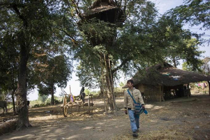 A man walking past a tree house in Taik Kyi village on the outskirts of Yangon. Photo: Ye Aung Thu/AFP
