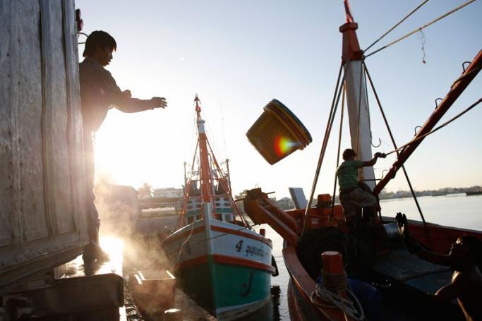 Migrant fishermen from Myanmar unload frozen fish from a Thai fishing boat after they stopped fishing operations at a port in Samut Sakhon province, Thailand, 01 July 2015. Photo: Rungroj Yongrit/EPA
