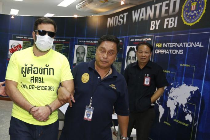Cracking down on drug traffickers - Alleged drug trafficker, French national Jonathan Plant (L), 40, is escorted by police officers for a press conference at the Immigration Bureau in Bangkok, Thailand, July 30, 2014. Photo: EPA
