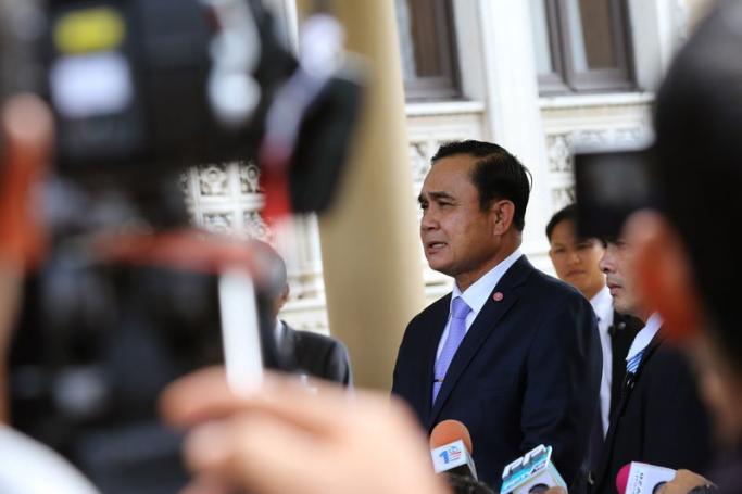 Thai Prime Minister Prayut Chan-o-cha (C) speaks to members of the media at Government House in Bangkok on 22 May, the anniversary of his military coup. Photo: Narong Sangnak/EPA  
