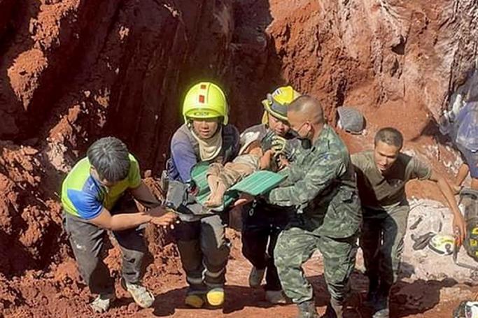 A handout photo made available by the Payap rescue club shows Thai rescuers and soldiers carrying a Myanmar girl to a hospital after she was rescued from a deep groundwater hole at a cassava plantation in Phop Phra district, Tak province, Thailand, 07 February 2023. Photo: EPA