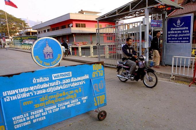 A Thai man rides a motorcycle past a check-point at the Thailand-Myanmar border in Mae Sai district. Photo: AFP
