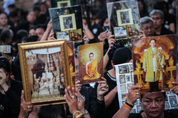 Thai mourners hold pictures of the late Thai King Bhumibol Adulyadej as they wait for the royal cremation ceremony outside the Royal Palace in Bangkok, Thailand, 26 October 2017. Photo: Diego Azubel/EPA-EFE
