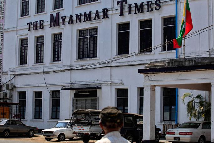 A pedestrian looks at the building of The Myanmar Times, Yangon. Photo: Nyein Chan Naing/EPA
