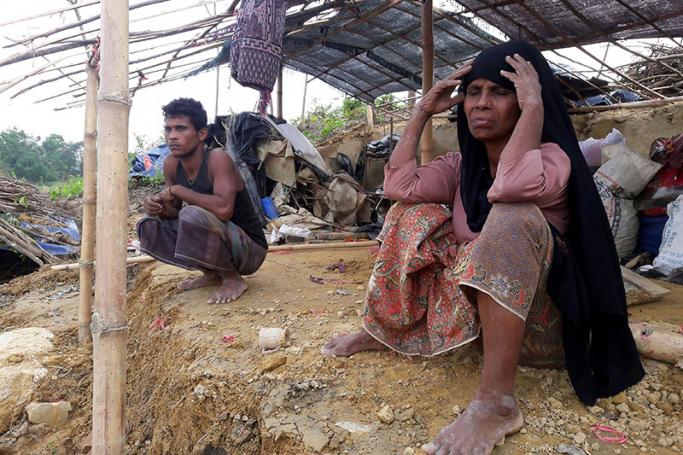 (FILES) This file photo taken on May 31, 2017 shows Rohingya refugees sitting near a house destroyed by Cyclone Mora in a camp in the Cox's Bazar district. The UN was "deeply concerned" on August 23, 2017 after Bangladesh coastguards turned back a boat carrying 31 Rohingya Muslim refugees escaping renewed army activity in their neighbouring Myanmar homeland. Photo: AFP
