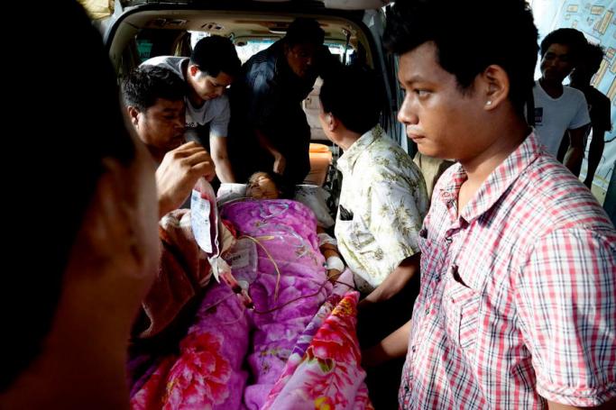 Rakhine Volunteers carry an injured Rakhine ethnic woman as they arrive to Sittwe Hospital in Sittwe, Rakhine State, Western Myanmar, 24 August 2019. According to reports, three  people died and several others are injured after heavy weapons and bullets hit the houses in the village of Pyan Mraung near Min Bya township during clashes  between the Myanmar military and the Arakan Army (AA) on 24 August. Photo: Nyunt Win/EPA