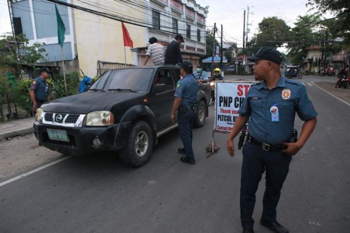 Policemen man a checkpoint between the border of Tanjay City and Pamplona town in the Philippine Province of Negros Oriental on March 4, 2023, hours after the provincial governor Roel Degamo and five others were killed by unknown gunmen. Photo: AFP