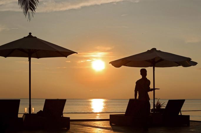 Hotel waiter serves during the setting sun on Ngwe Saung beach, also called Silver Sands, near Ngwe Saung township, some 260 km from Yangon in Pathein province, Ayeyarwaddy Devision, Myanmar. Photo: EPA
