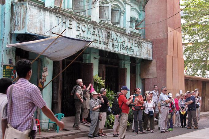 A group of western tourists visiting the Myanmar old colonial building (The Bombay Burma Press), Yangon. Photo: Nyein Chan Naing/EPA
