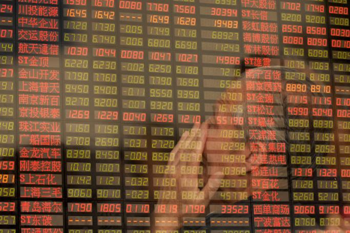 A multiple exposure picture shows an investor monitors the index price at a stock exchange market in Shanghai, China. Photo: Wenhao Yu/EPA
