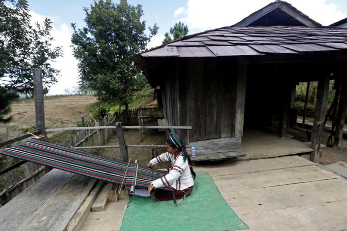 A Chin woman weaving cloth in front of a traditional Chin house at the Siangsawn model village in Tedim city, Chin State, Myanmar. Photo: Nyein Chan Naing/EPA
