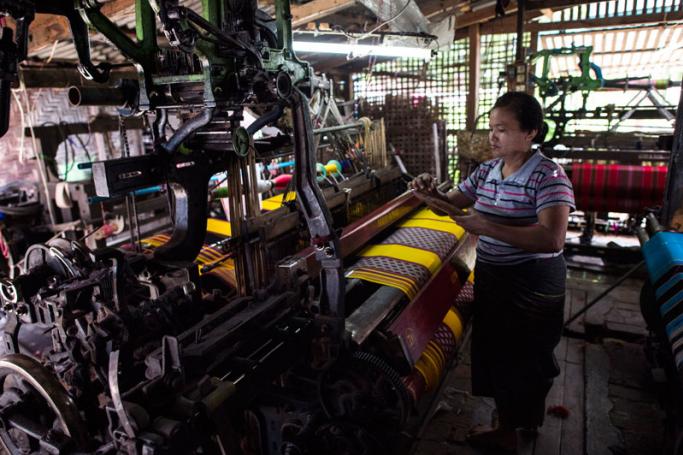 A woman working to make traditional Myanmar clothing at a workshop in Mandalay. Photo: Ye Aung Thu/AFP
