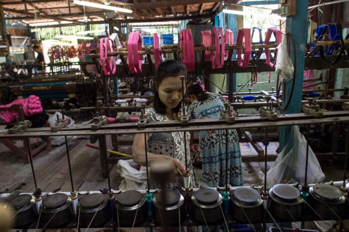 Women weaving silk on looms for traditional Myanmar clothing at a workshop in Mandalay. Photo: Ye Aung Thu/AFP