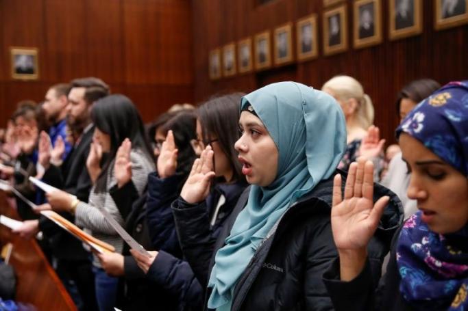 Concerns have been expressed by refugees who have made it to the United States -  Lila Mubarak, pictured (second from right) at a naturalization ceremony on February 10, escaped Myanmar and reached Malaysia before setting out for the US (AFP Photo/KAMIL KRZACZYNSKI)