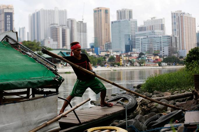 A Filipino ferryman steers his boat at a river on Christmas eve in Makati city, south of Manila, Philippines, 24 December 2016. The Philippines is one of the most typhoon-prone countries in the world, and over a dozen tropical storms pass through the archipelago every year bringing risks of damage and casualties. Photo: Francis R. Malasig/EPA
