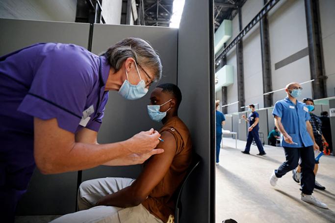 A member of the public receives the Pfizer-BioNTech Covid-19 vaccine in the Turbine Hall at a temporary Covid-19 vaccine centre at the Tate Modern in central London. Photo: AFP