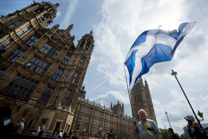 (ၤFile) A supporter of the Scottish National Party (SNP) holds a Scotland Flag in Westminster before newly elected SNP Members of Parliament arrive for photographs, London, Britain 11 May 2015. Photo: EPA