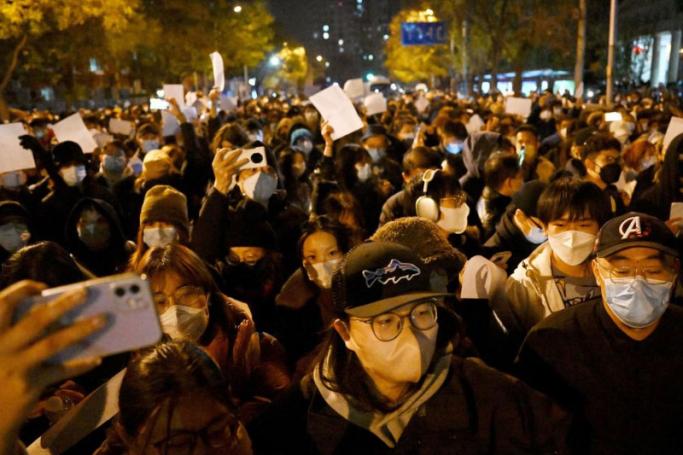 Protesters march along a street during a rally for the victims of a deadly fire as well as a protest against China's harsh Covid-19 restrictions in Beijing on November 28, 2022. Photo: AFP