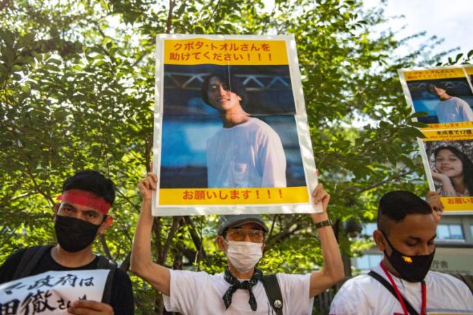 A group of activists hold up placards with the image of Japanese journalist Toru Kubota, who was detained in Myanmar, during a rally in front of the Ministry of Foreign Affairs in Tokyo in July 2022. On October 6, 2022, a Myanmar court sentenced Kubota to 10 years in prison on two charges. Photo: AFP