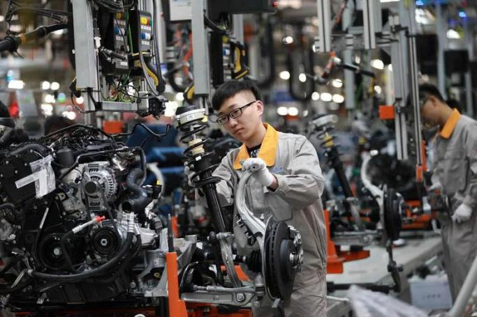 A Chinese employee working on a production line of automobiles at a factory in Changchun. Photo: AFP