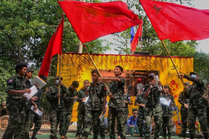 This picture taken on April 15, 2022 shows members of the "Peacock Generation" activist troupe, some of whom are dressed as part of the "People's Defence Forces" (PDF), waving Yangon Student Union flags during a traditional "Thangyat" performance in Kayin state. Photo: AFP