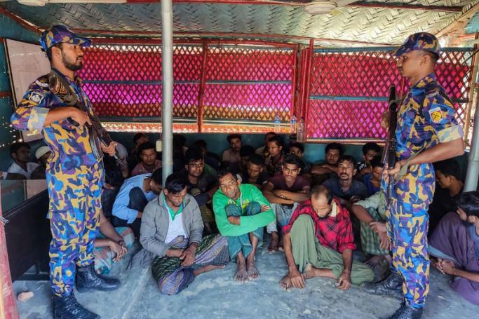 Bangladesh security personnel standing near detained Rohingya refugees after crackdown in Rohingya refugee camp in Ukhia. Photo: AFP