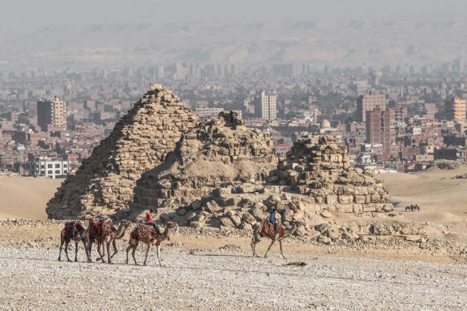 Egyptians ride camels at the Giza pyramids necropolis on the southwestern outskirts of the Egyptian capital Cairo on December 18, 2019. Photo: AFP