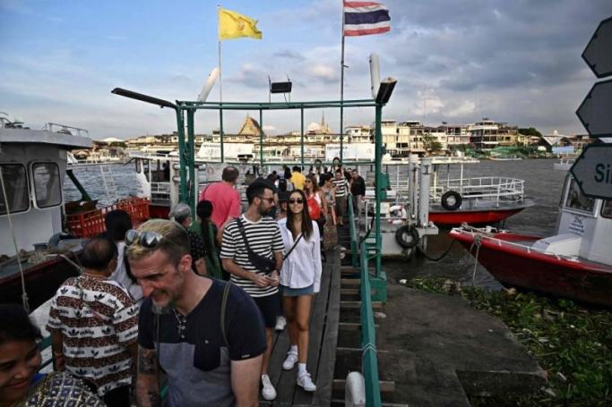 Tourists disembark from a commuter ferry on the Chao Praya River in Bangkok on December 9, 2022. Photo: AFP