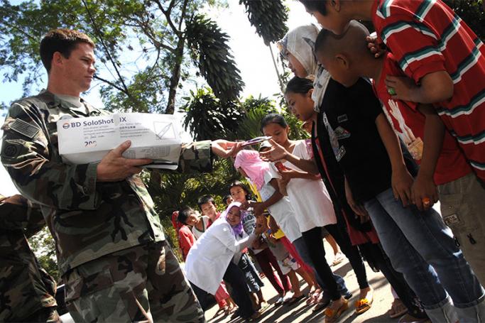 An Army Special Forces medic passes out toothpaste and toothbrushes to Philippine children during a local government-organized dental awareness and care initiative Feb. 22, 2010, in Mawari, Philippines. Photo: Army Sgt. 1st Class Michael J. Carden/defense.gov
