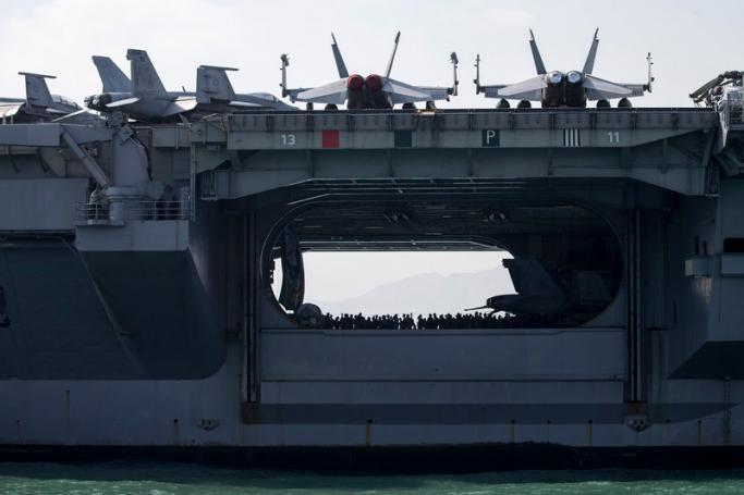 Sailors stand in the hangar aircraft carrier USS Ronald Reagan after mooring in Victoria Harbour in Hong Kong, China. Photo: EPA